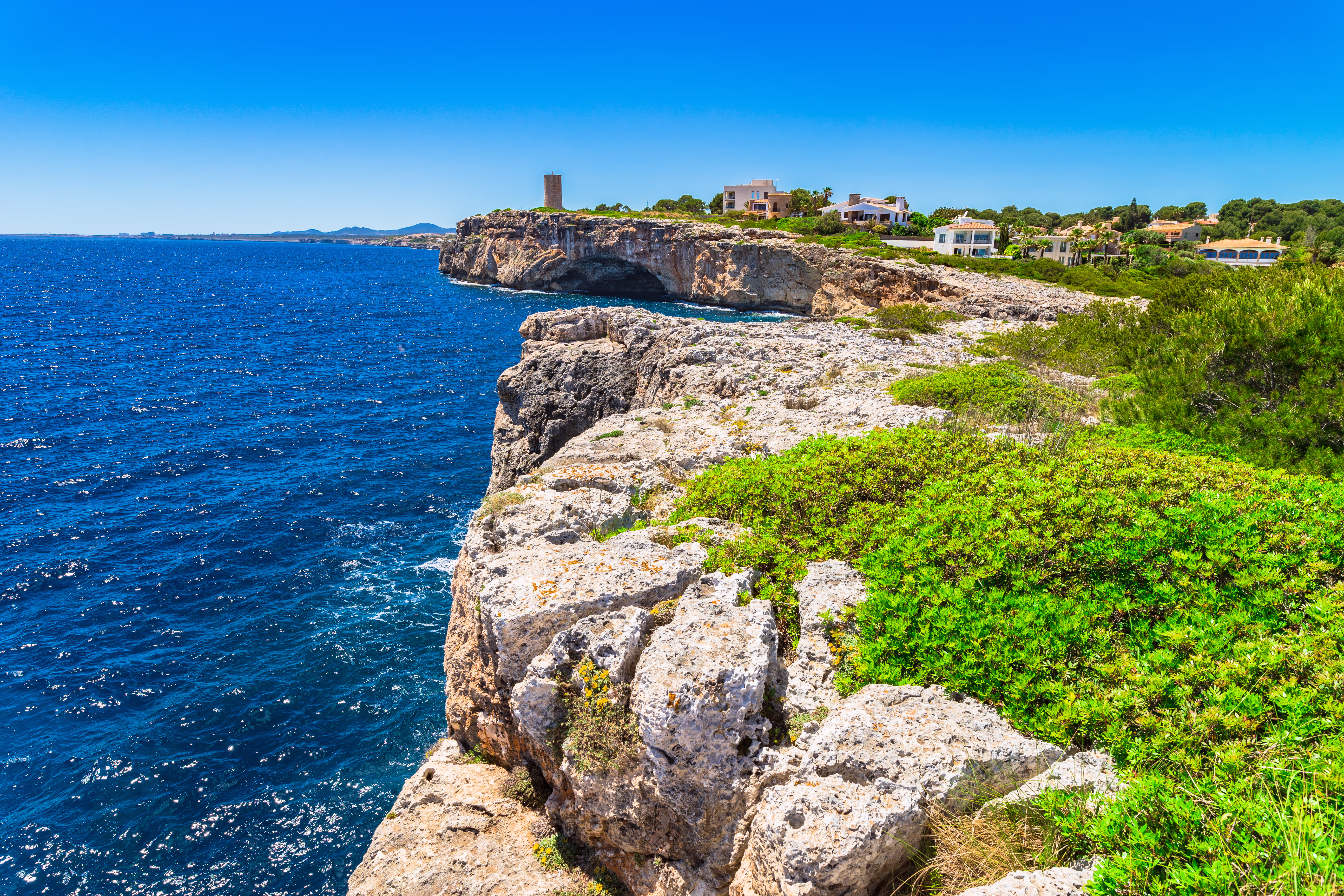 Cliff coast of Porto Cristo with the old watchtower in the background Cliff coast of Porto Cristo with the old watchtower in the background