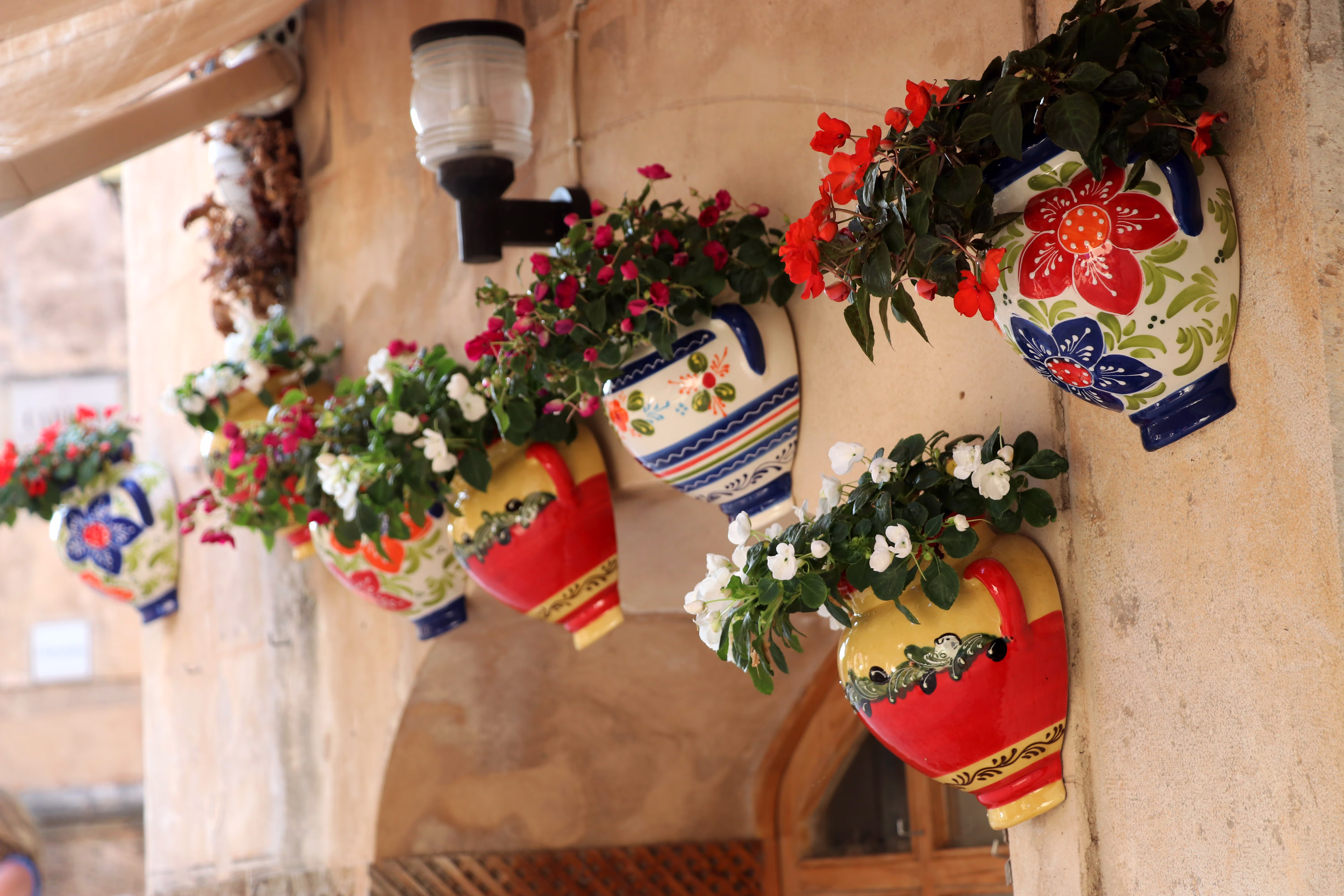 Colorful, beautifully planted flower pots adorn the entrance to a house Colorful, beautifully planted flower pots adorn the entrance to a house