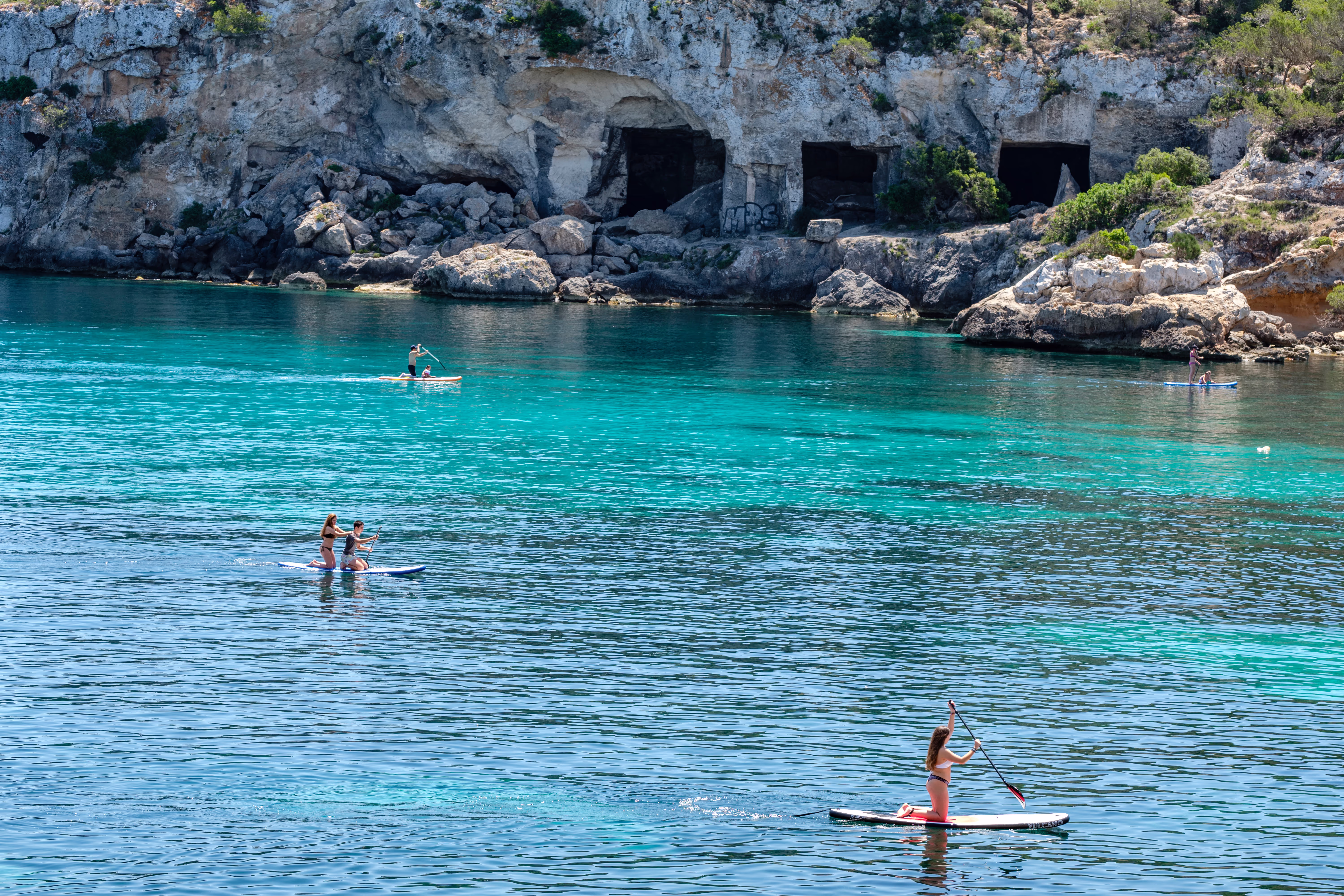 Kayaks in front of the cave entrances of Portals Vells Kayaks in front of the cave entrances of Portals Vells