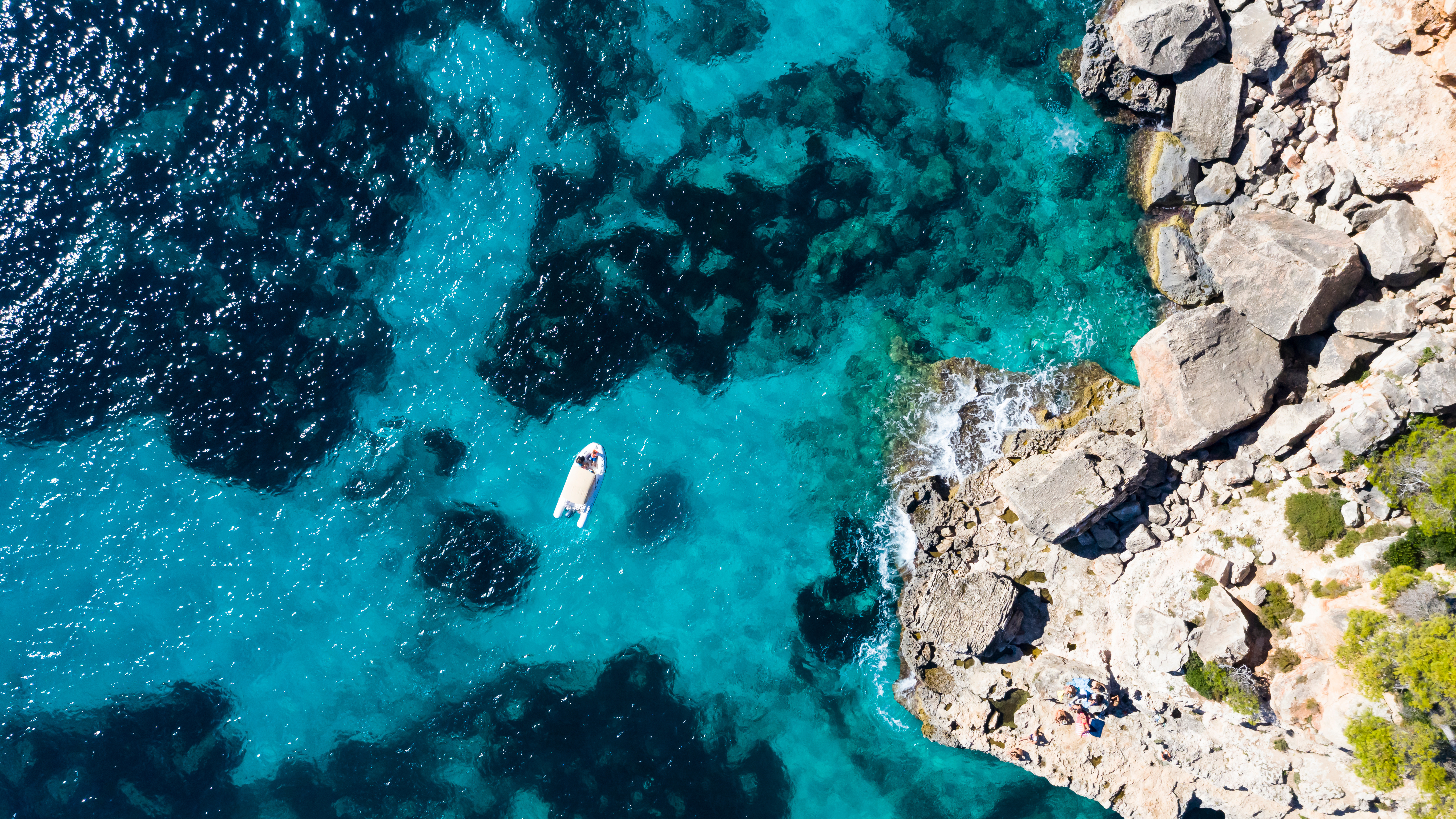 Aerial view of Cala Llombards bay. Turquoise waters alternating with deep blue.