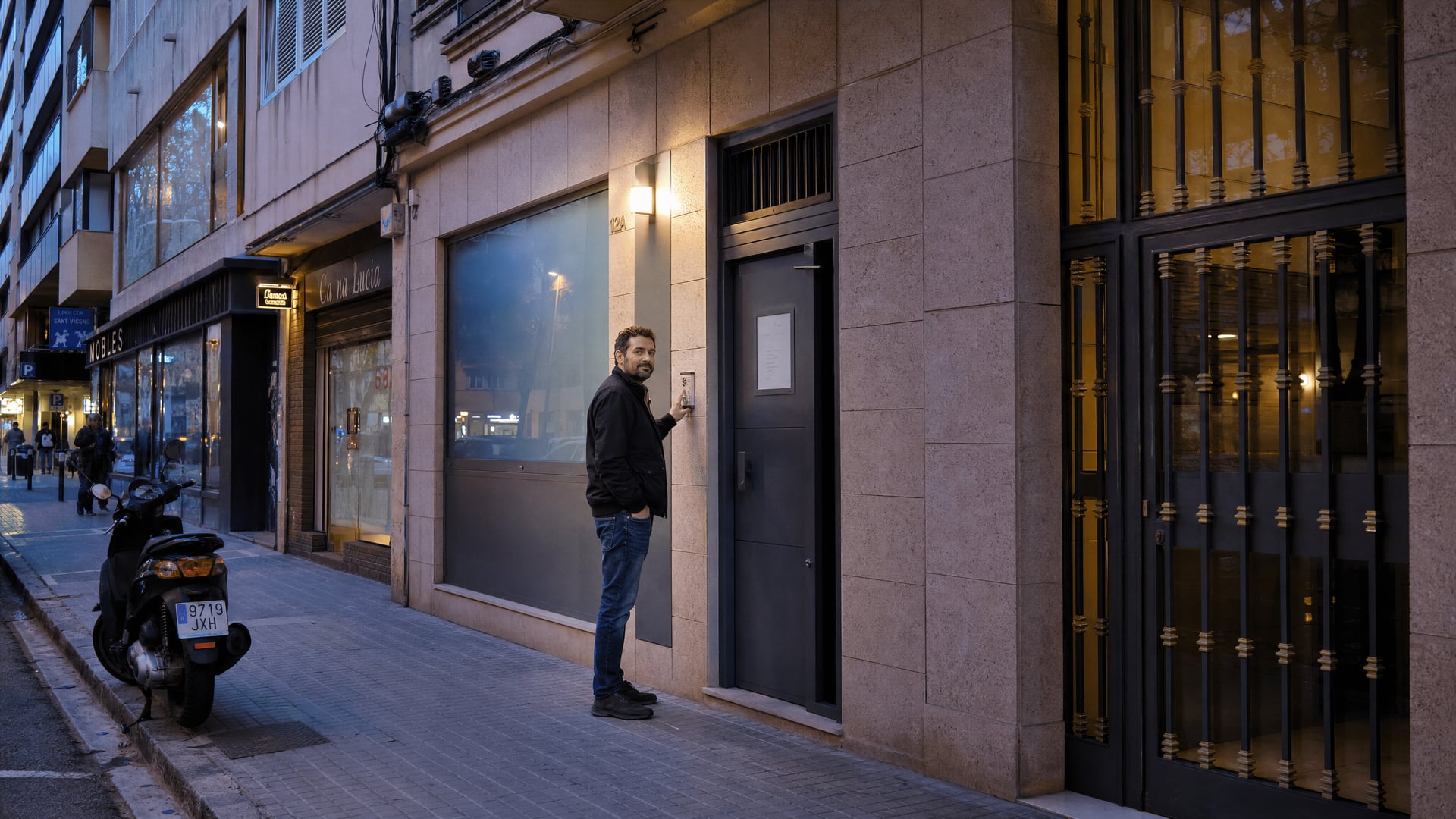 Entrée discrète d’un club privé au rez-de-chaussée d’un immeuble commercial ordinaire de Palma, avec vitre dépolie et sans publicité pour le cannabis.